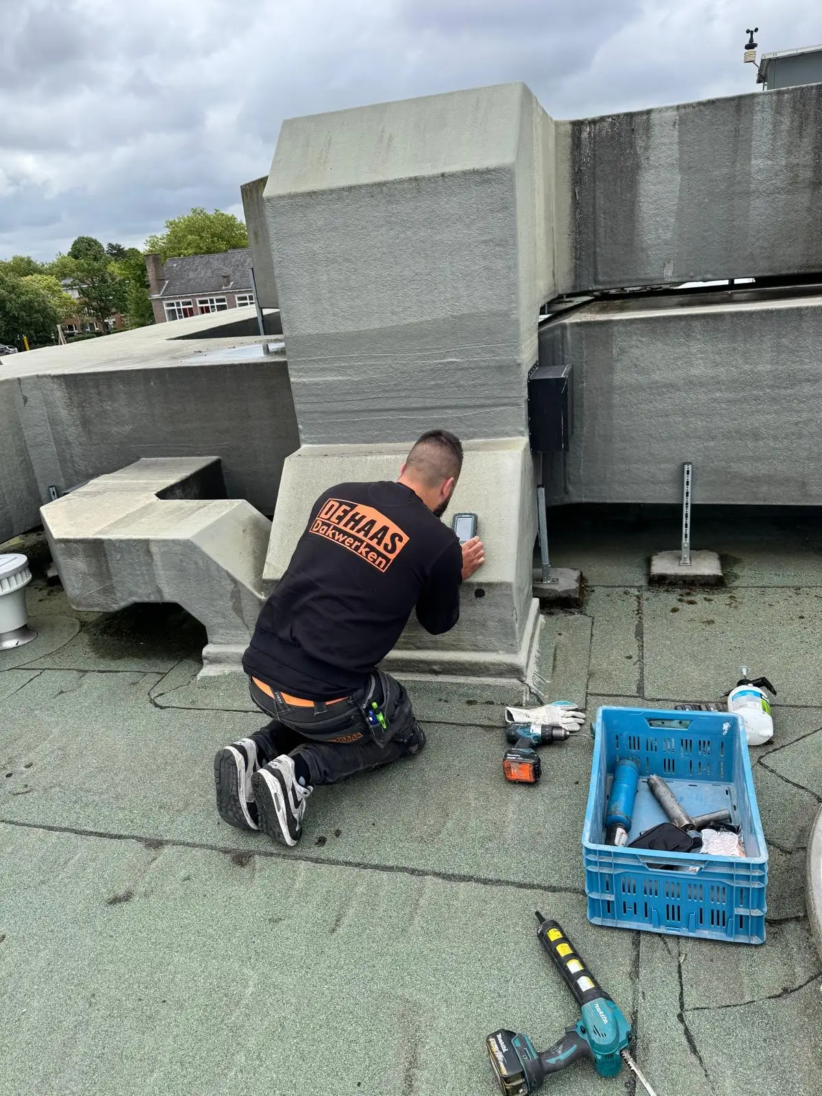 Medewerker van De Haas doet een meting op een plat dak